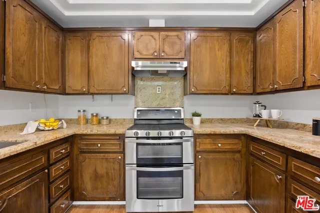 a kitchen with granite countertop a sink and a stove