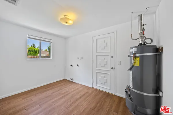 a view of empty room with wooden floor and window