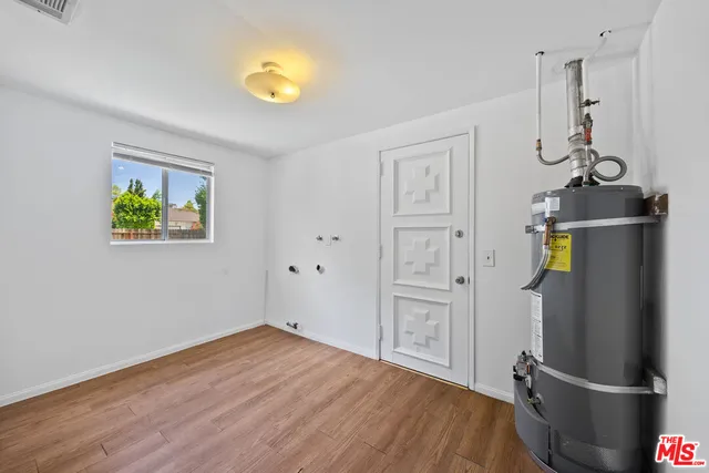 a view of empty room with wooden floor and window