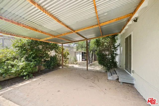 a backyard of a house with garden and outdoor seating