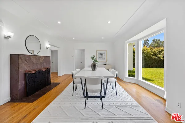 a dining room with furniture a fireplace and wooden floor