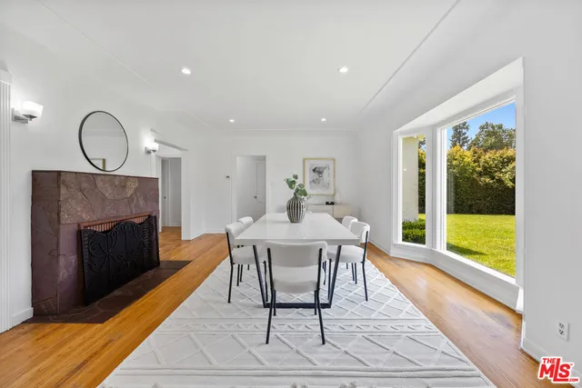 a dining room with furniture a fireplace and wooden floor