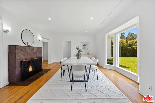 a dining room with furniture a fireplace and wooden floor