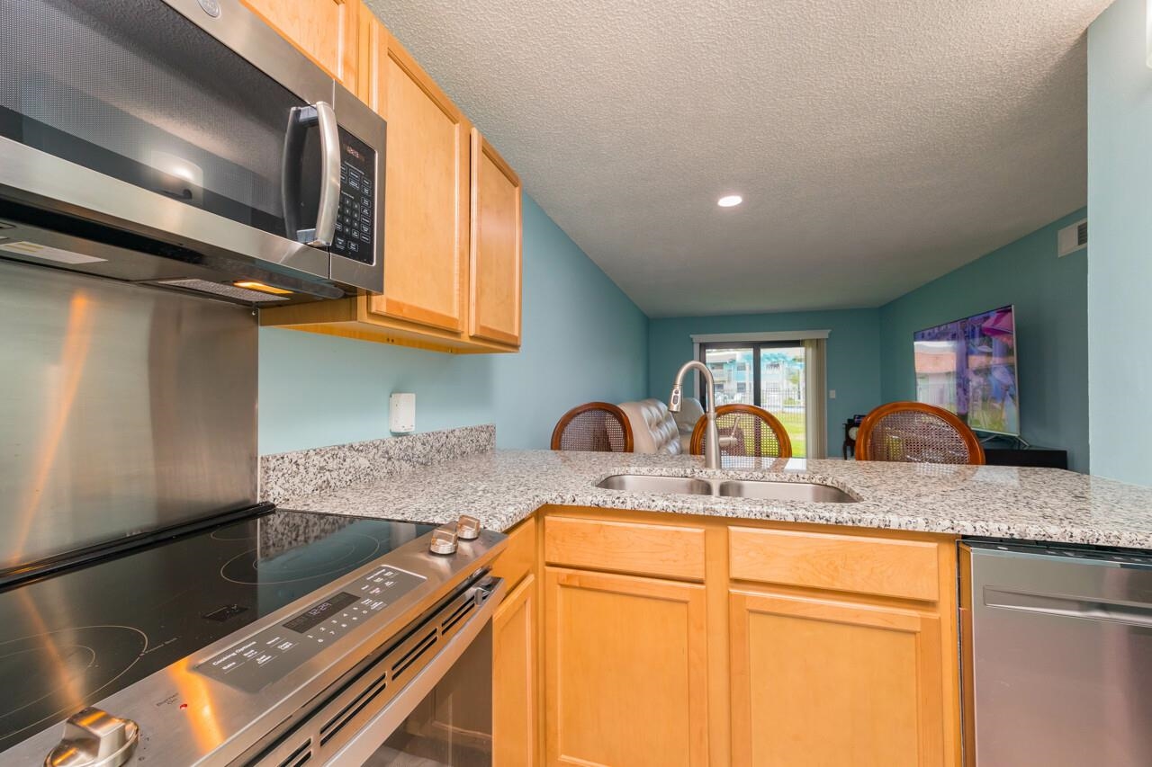 650 West Pope Road, Unit 240 St. Augustine, FL 32080 - Photo 14 of 35 a kitchen with stainless steel appliances granite countertop a sink and a microwave