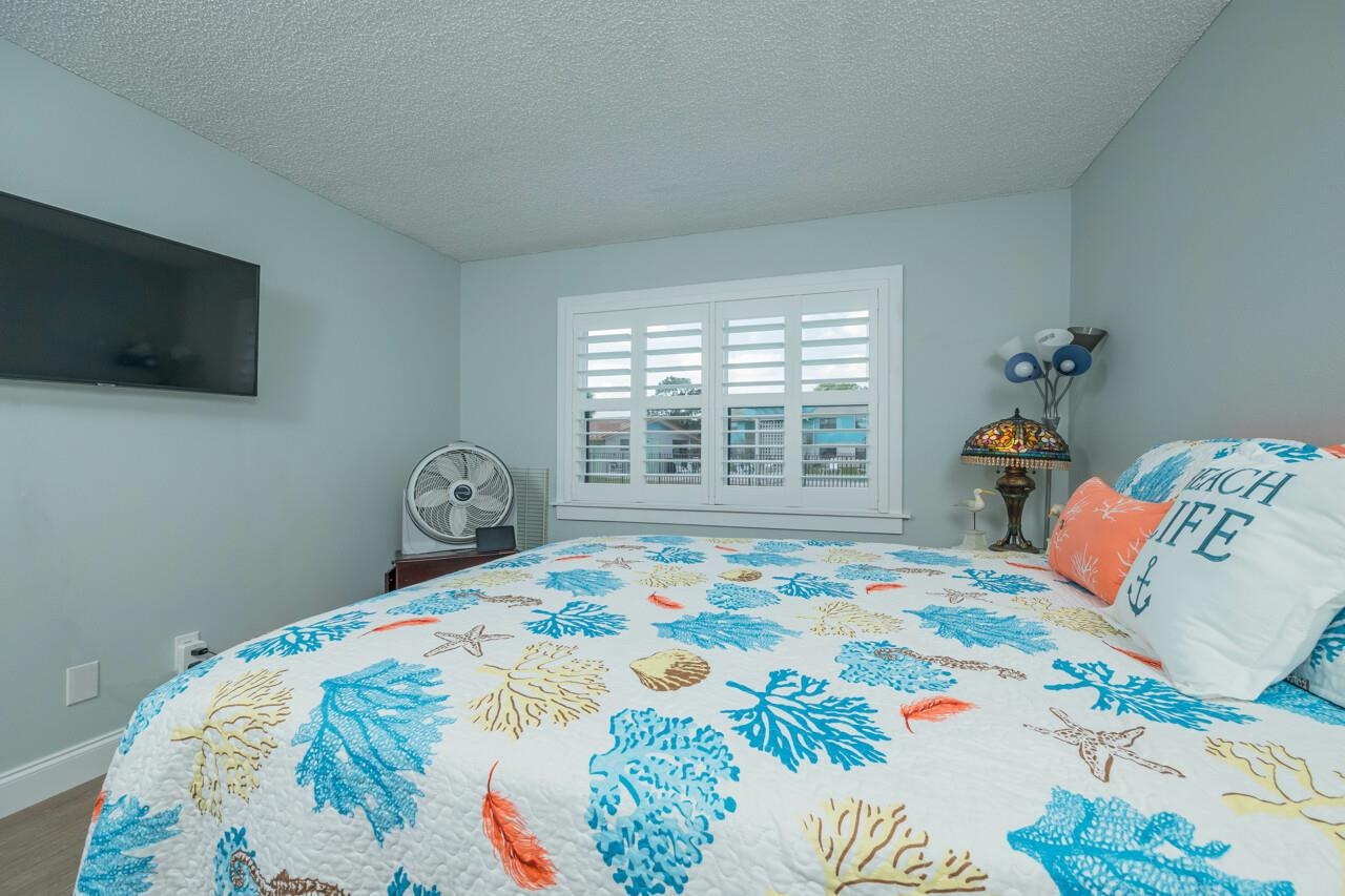 650 West Pope Road, Unit 240 St. Augustine, FL 32080 - Photo 17 of 35 a bedroom with a bed and flat screen tv