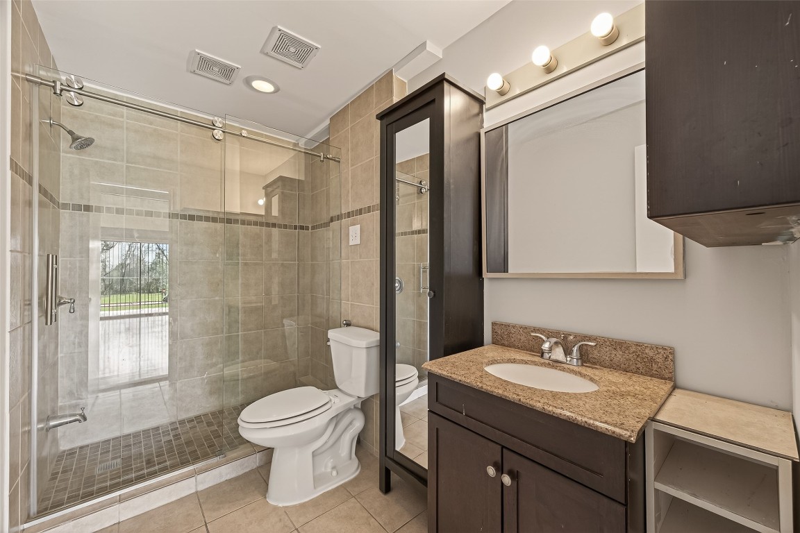 8483 Sands Point Drive Houston, TX 77036 - Photo 14 of 23 a bathroom with a granite countertop sink toilet a mirror a vanity and shower