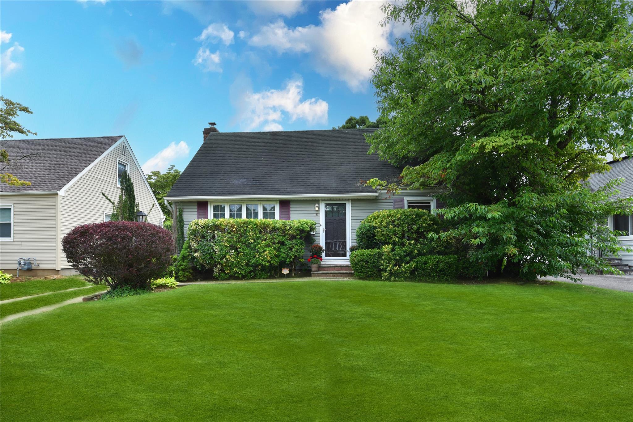 36 Alhambra Road Baldwin, NY 11510 - Photo 1 of 1 View of front facade featuring a front yard, roof with shingles, and a chimney