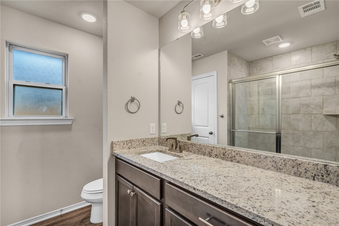 1236 High Street Navasota, TX 77868 - Photo 12 of 14 a bathroom with a granite countertop sink a toilet and shower