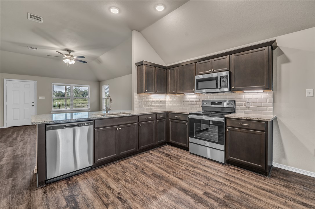1236 High Street Navasota, TX 77868 - Photo 5 of 14 a kitchen with stainless steel appliances kitchen island granite countertop a stove cabinets and wooden floor