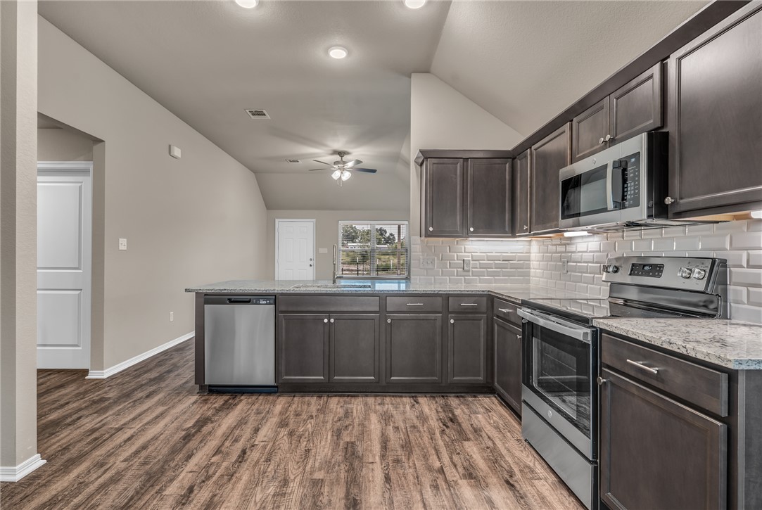 1236 High Street Navasota, TX 77868 - Photo 6 of 14 a kitchen with stainless steel appliances granite countertop a sink and stove top oven