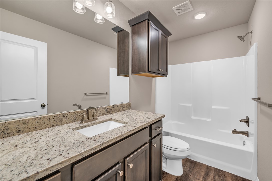 1236 High Street Navasota, TX 77868 - Photo 9 of 14 a bathroom with a granite countertop sink toilet and shower
