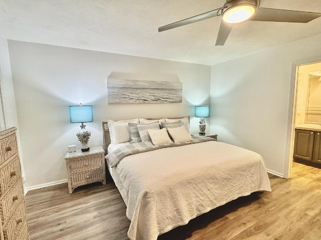 755 Saturn Street, Unit E201 Jupiter, FL 33477 - Photo 11 of 27 a bedroom with a bed and wooden floor