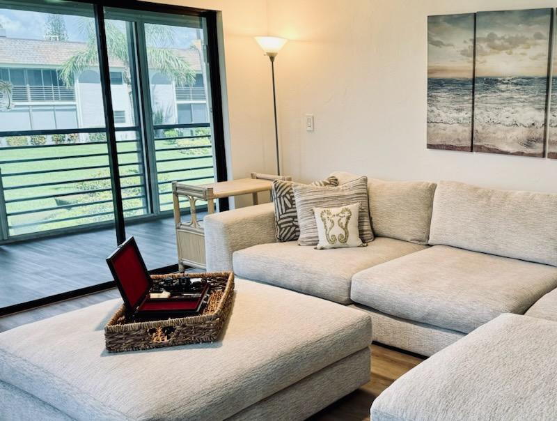 755 Saturn Street, Unit E201 Jupiter, FL 33477 - Photo 5 of 27 a living room with furniture and a large window