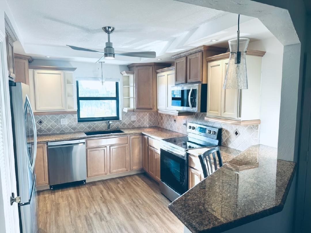 755 Saturn Street, Unit E201 Jupiter, FL 33477 - Photo 9 of 27 a kitchen with stainless steel appliances granite countertop a sink stove and refrigerator