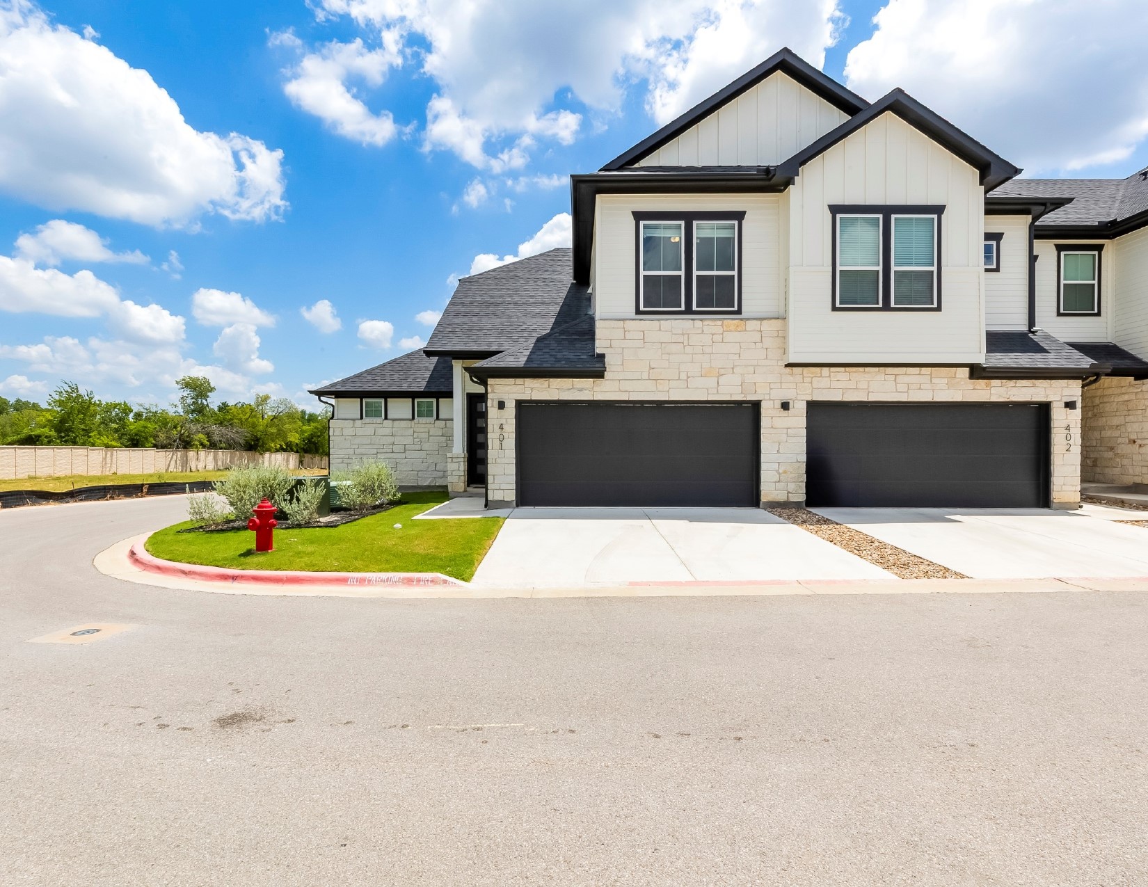 2600 Gattis School Road, Unit 401 Round Rock, TX 78664 - Photo 1 of 29 View of front of house featuring stone siding, concrete driveway, board and batten siding, a shingled roof, and an attached garage