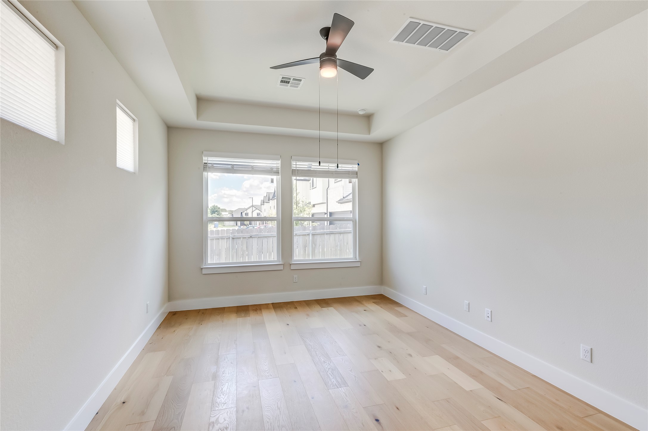 2600 Gattis School Road, Unit 401 Round Rock, TX 78664 - Photo 20 of 29 Empty room with a tray ceiling, light wood-type flooring, and a ceiling fan
