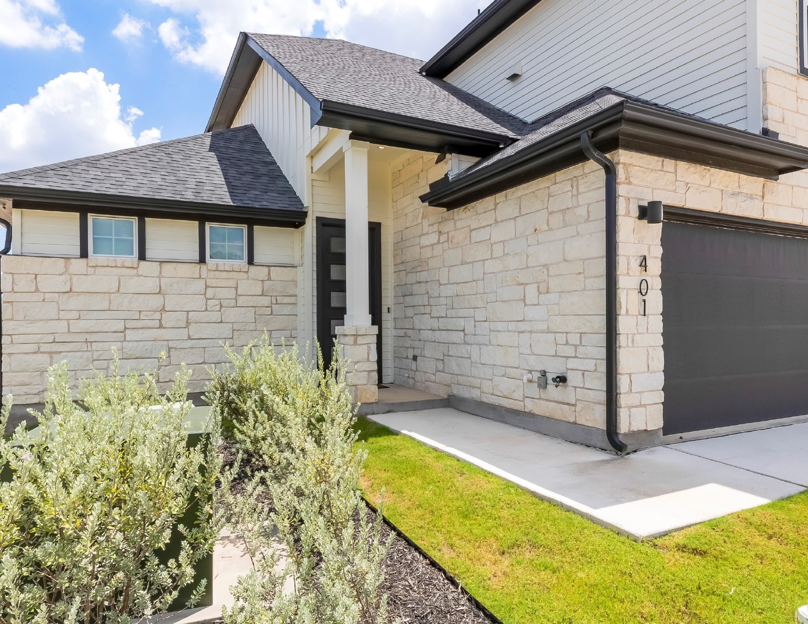 2600 Gattis School Road, Unit 401 Round Rock, TX 78664 - Photo 3 of 29 Entrance to property with stone siding, a garage, roof with shingles, and board and batten siding