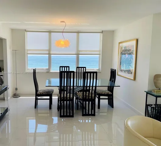 a dining room with furniture a rug and a large window
