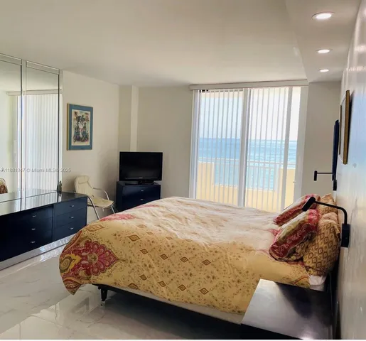 a bedroom with a bed and a lamp on dresser