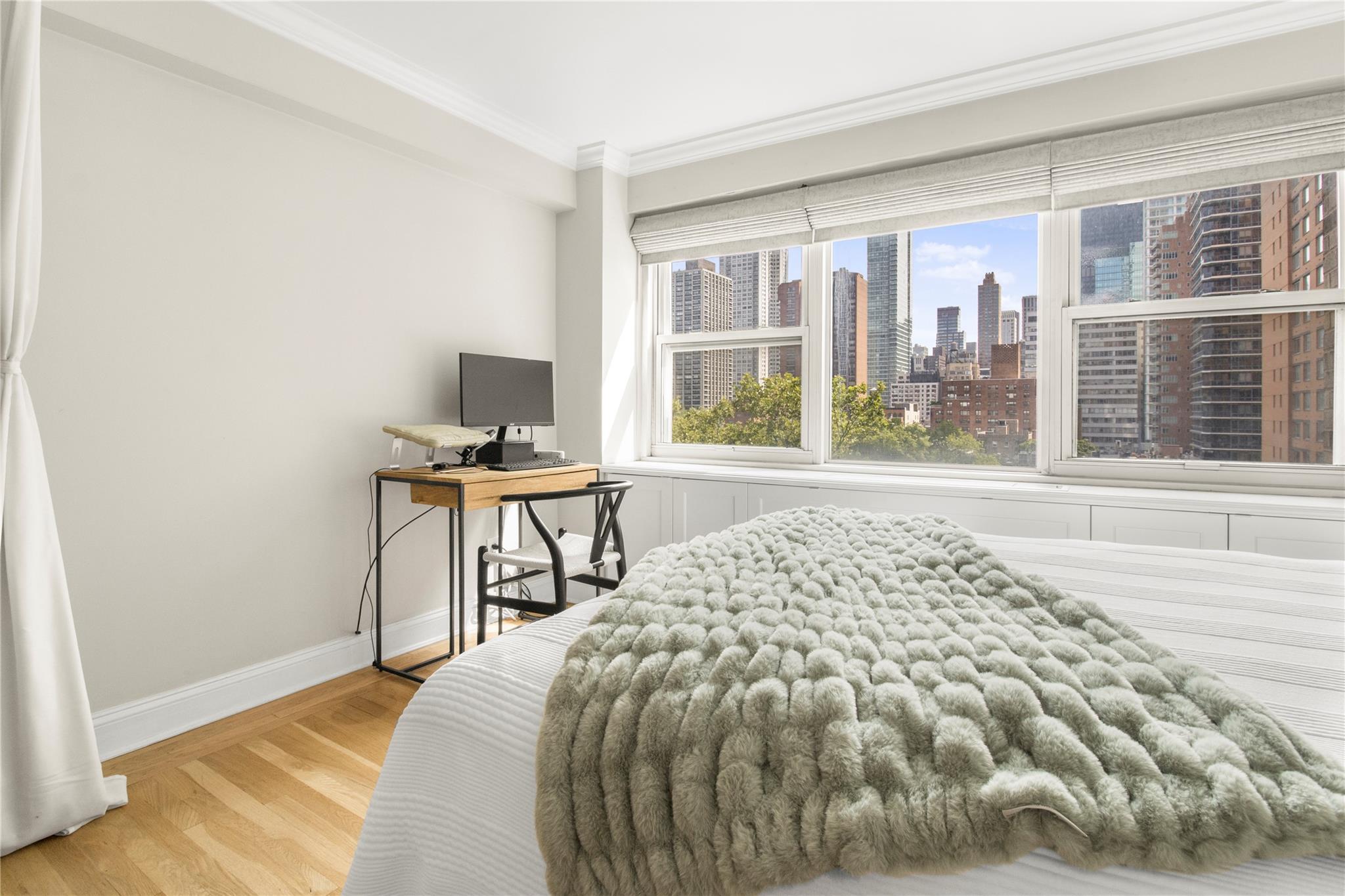 Bedroom with crown molding, light wood-style flooring, and baseboards