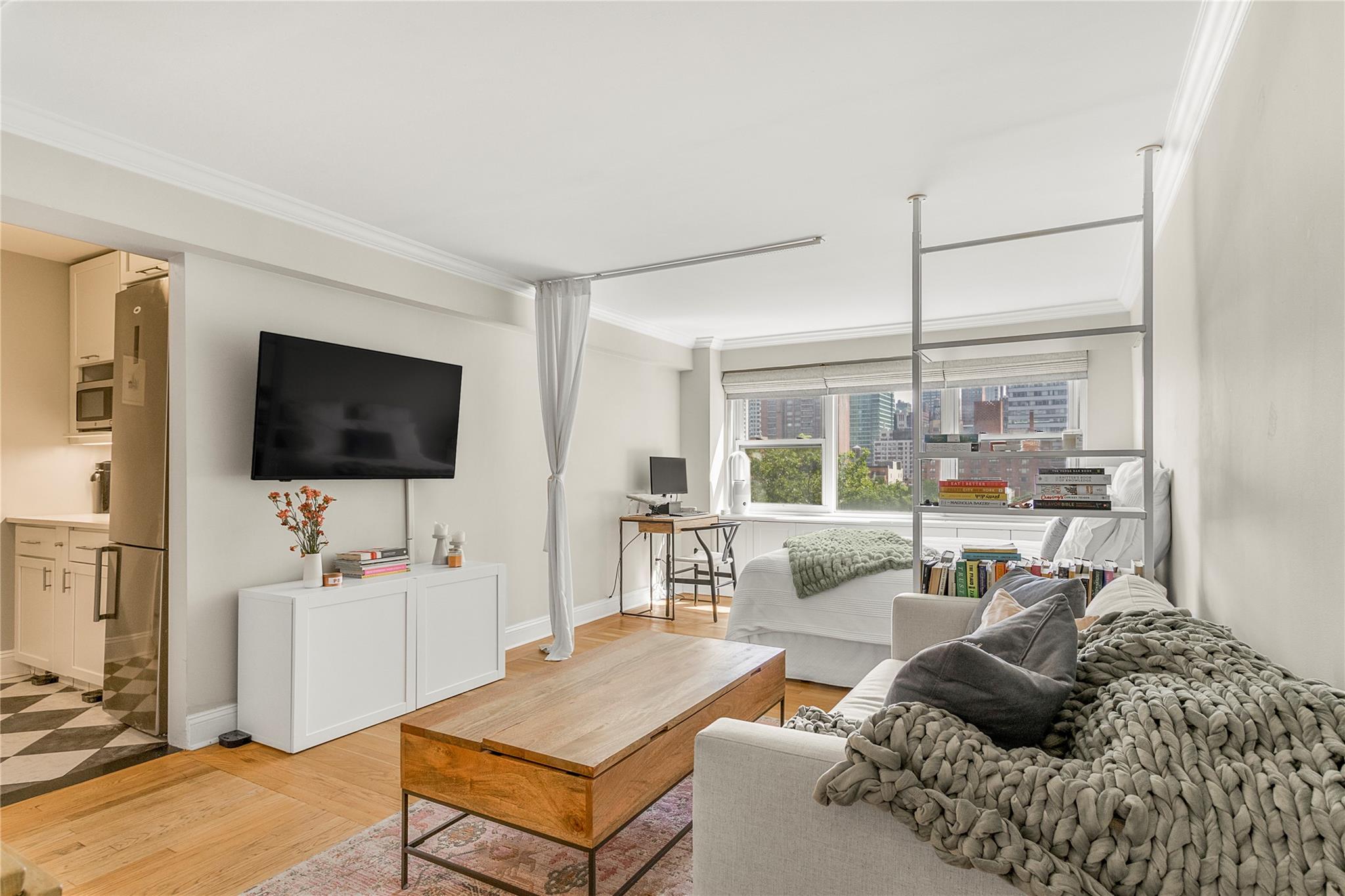210 East 63rd Street, Unit 10E Manhattan, NY 10065 - Photo 4 of 15 Living area featuring ornamental molding, light wood-style floors, and baseboards