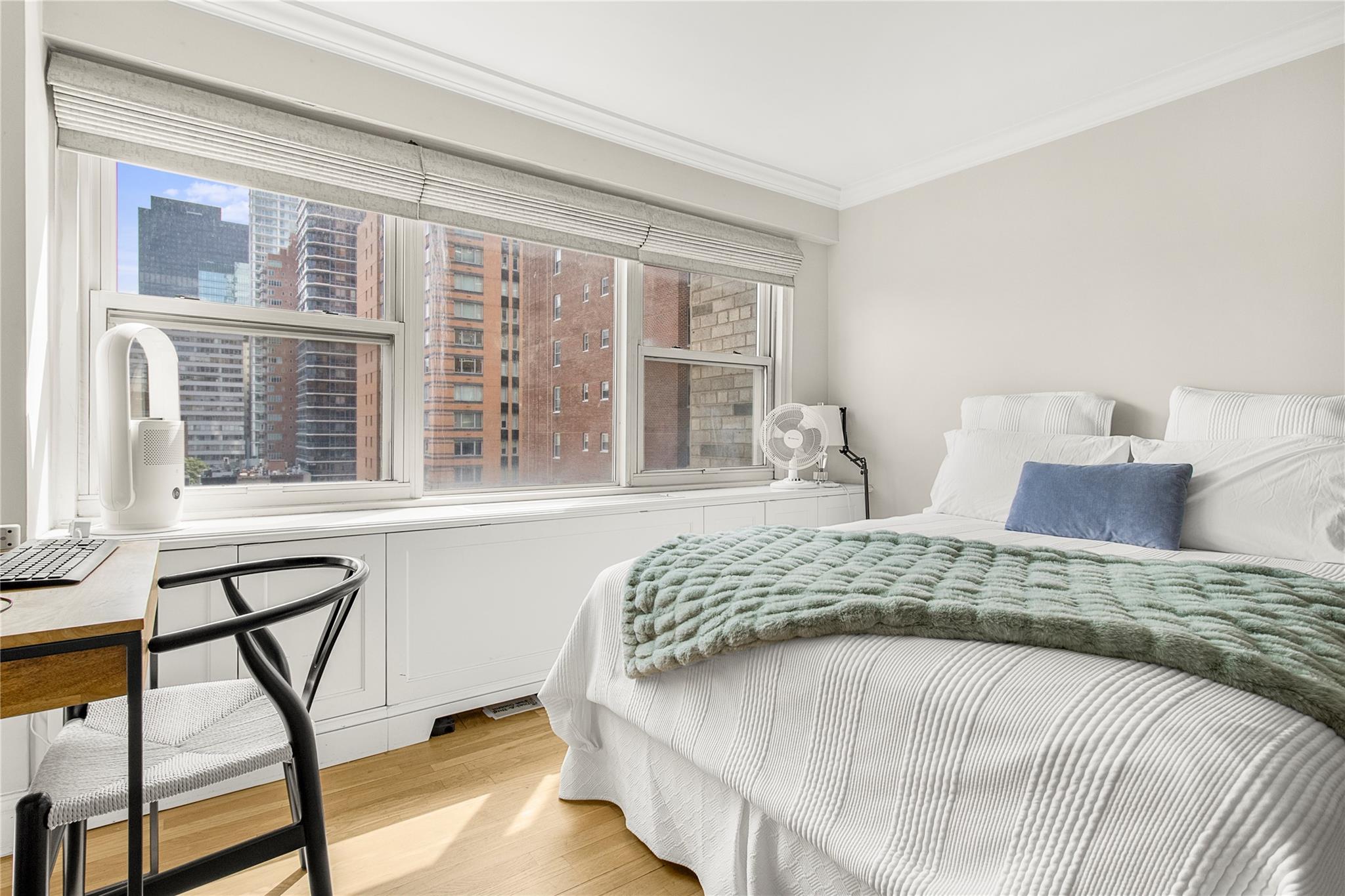 210 East 63rd Street, Unit 10E Manhattan, NY 10065 - Photo 5 of 15 Bedroom with ornamental molding, light wood finished floors, an office area, and a city view