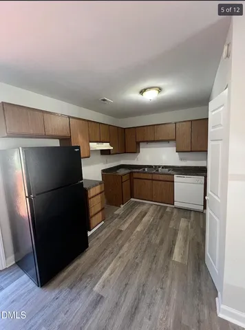 a kitchen with granite countertop a refrigerator and a sink