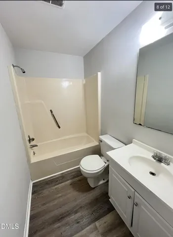 a bathroom with a sink a toilet a mirror and shower