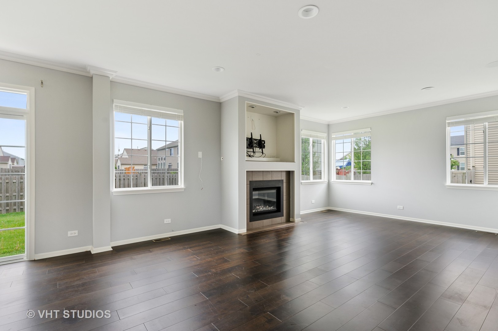 1439 Viola Lane Volo, IL 60073 - Photo 5 of 11 an empty room with wooden floor fireplace and windows