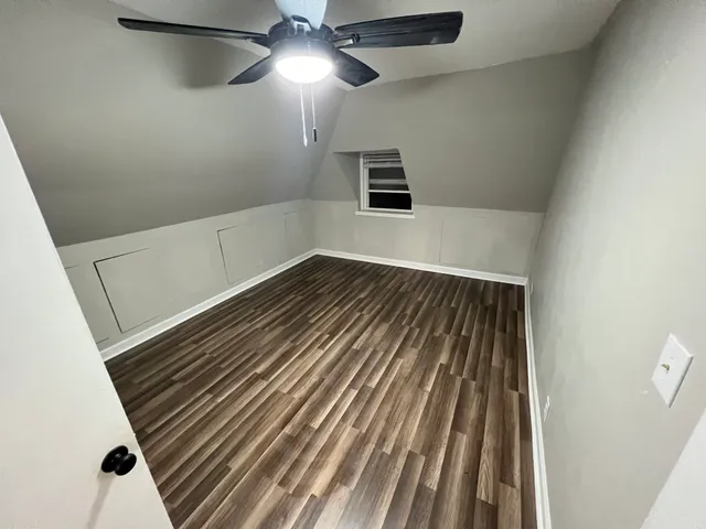 en empty room with wooden floor fan and windows