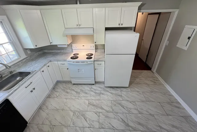 a kitchen with cabinets and a refrigerator
