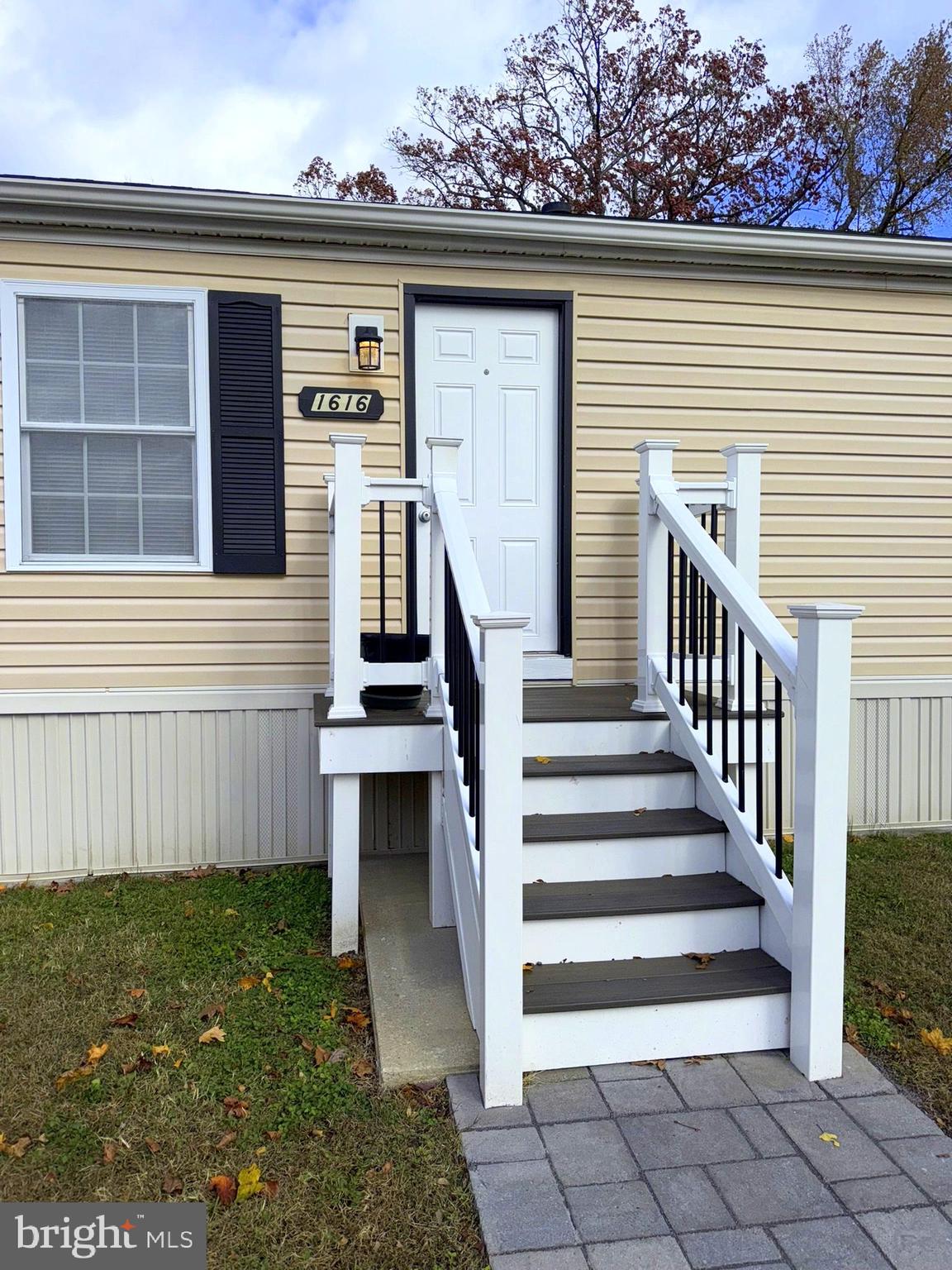 a view of a house with a small yard and wooden floor and fence