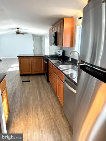 a kitchen with stainless steel appliances granite countertop a stove a sink and a refrigerator