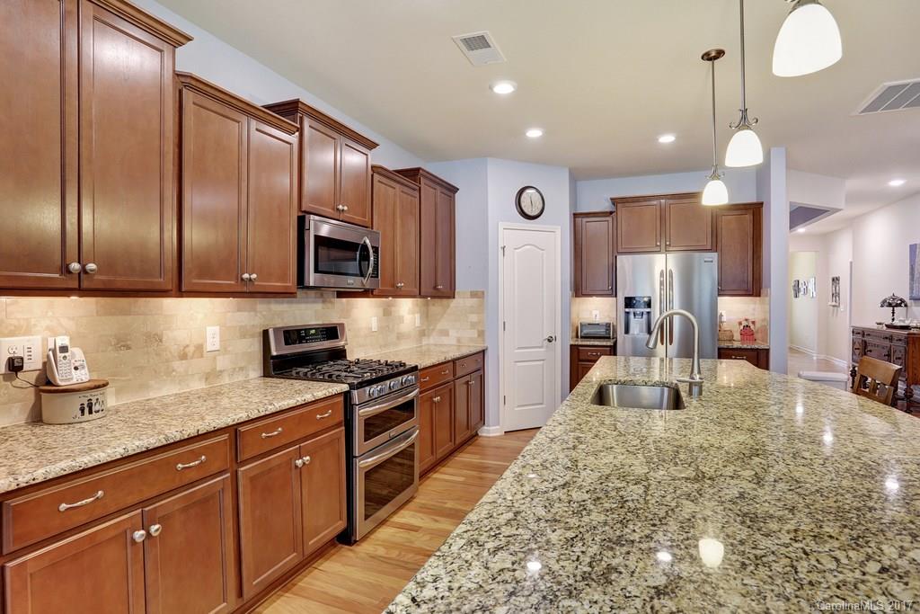 4135 Perth Road, Unit 374 Indian Land, SC 29707 - Photo 13 of 24 a large kitchen with stainless steel appliances granite countertop a stove a sink dishwasher a microwave oven with cabinets and wooden floor