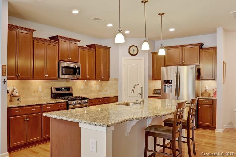 4135 Perth Road, Unit 374 Indian Land, SC 29707 - Photo 14 of 24 a kitchen with granite countertop a table chairs microwave and refrigerator