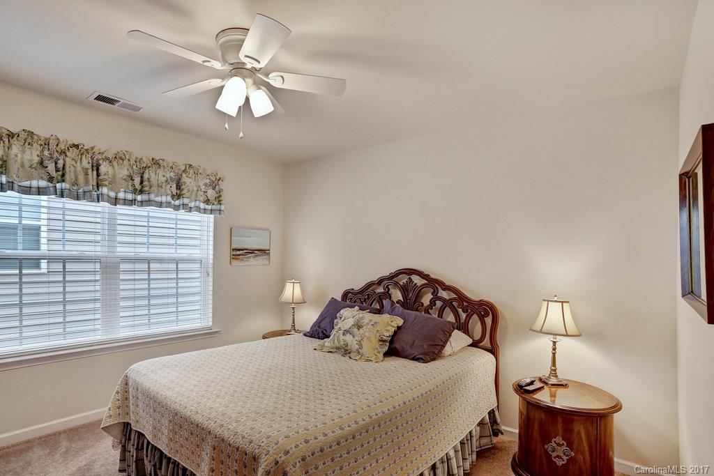 4135 Perth Road, Unit 374 Indian Land, SC 29707 - Photo 20 of 24 a bedroom with a bed and a chandelier