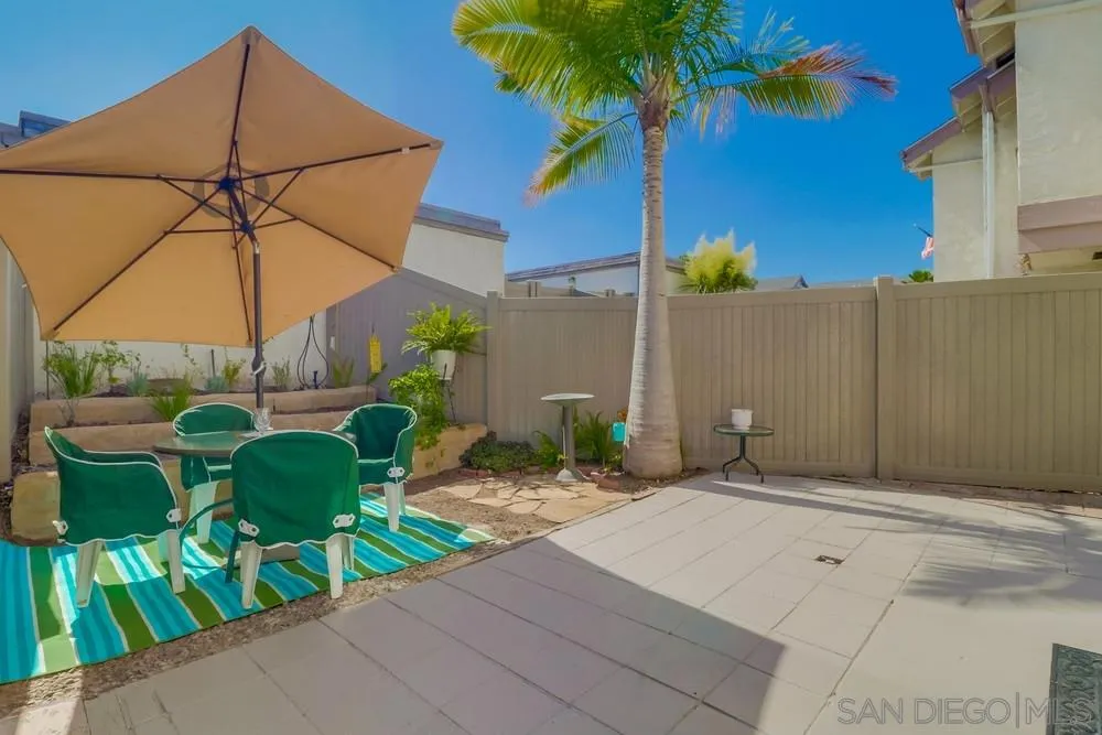 8701 Spring Canyon Drive Spring Valley, CA 91977 - Photo 18 of 24 a backyard of a house with table and chairs under an umbrella