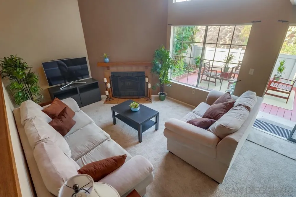8701 Spring Canyon Drive Spring Valley, CA 91977 - Photo 2 of 24 a living room with furniture a flat screen tv and a fireplace