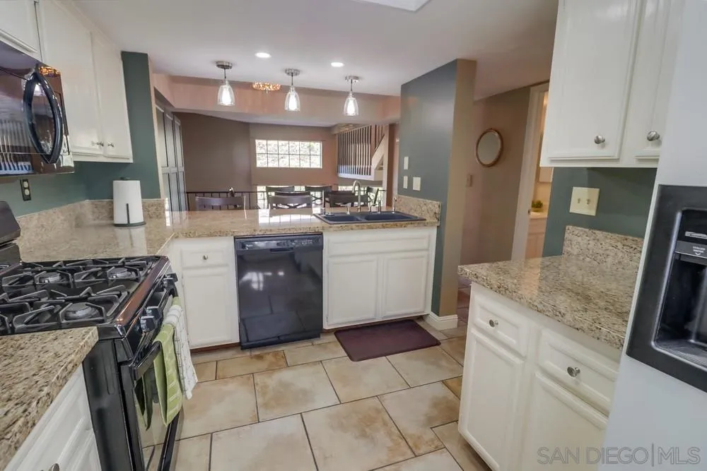 8701 Spring Canyon Drive Spring Valley, CA 91977 - Photo 5 of 24 a kitchen with granite countertop a sink a counter top space stove and cabinets
