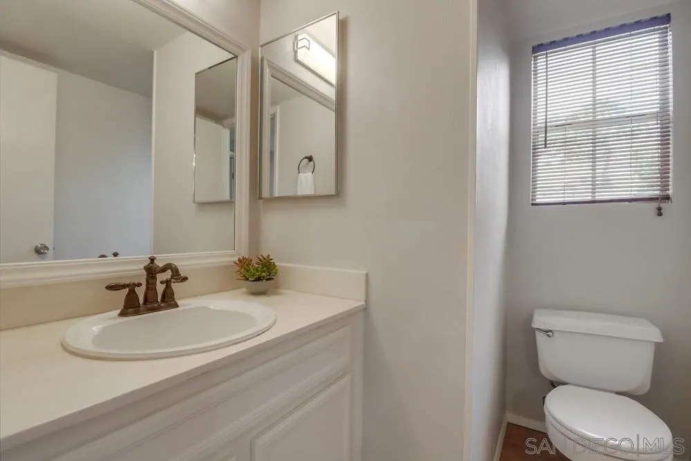 8701 Spring Canyon Drive Spring Valley, CA 91977 - Photo 10 of 24 a bathroom with a toilet a sink and mirror