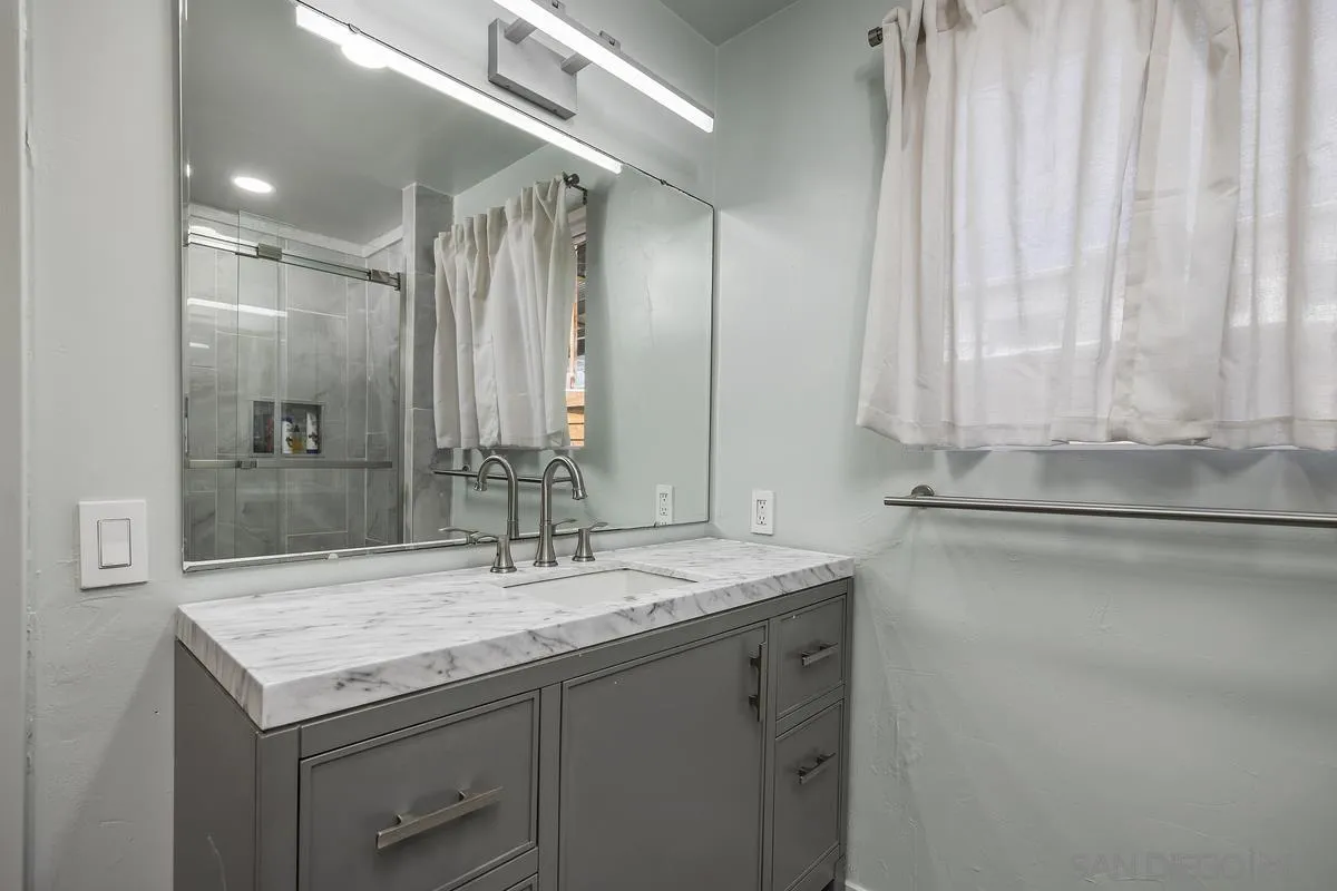 1211 East Mission Road Fallbrook, CA 92028 - Photo 19 of 31 a bathroom with a granite countertop sink and a mirror