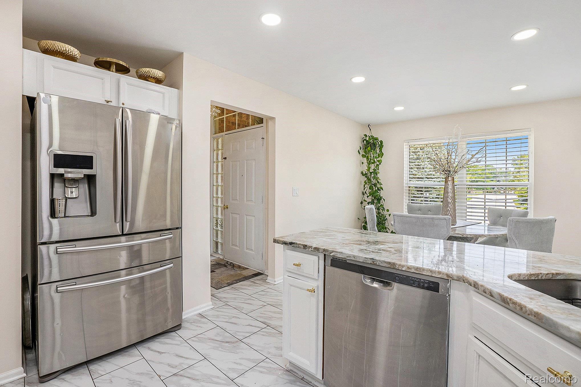 5477 Victory Circle Sterling Heights, MI 48310 - Photo 16 of 32 Kitchen featuring a stainless steel French door refrigerator, white cabinetry with gold-finish hardware, and marble-look tile flooring