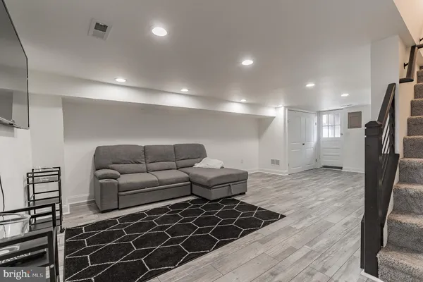 a living room with furniture a large window and wooden floor