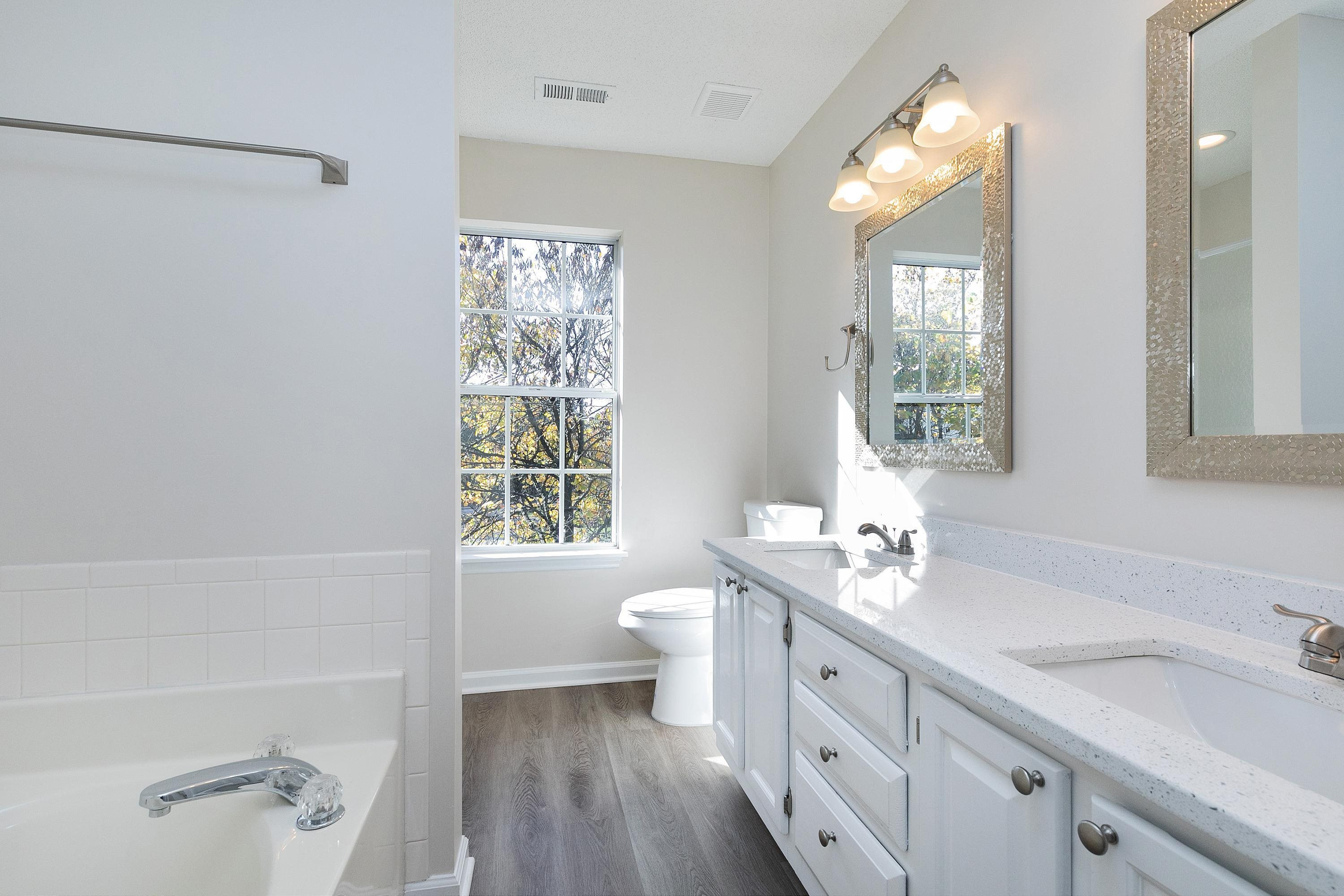 4424 Still Pines Drive Raleigh, NC 27613 - Photo 19 of 34 a spacious bathroom with a double vanity sink a large mirror and a toilet