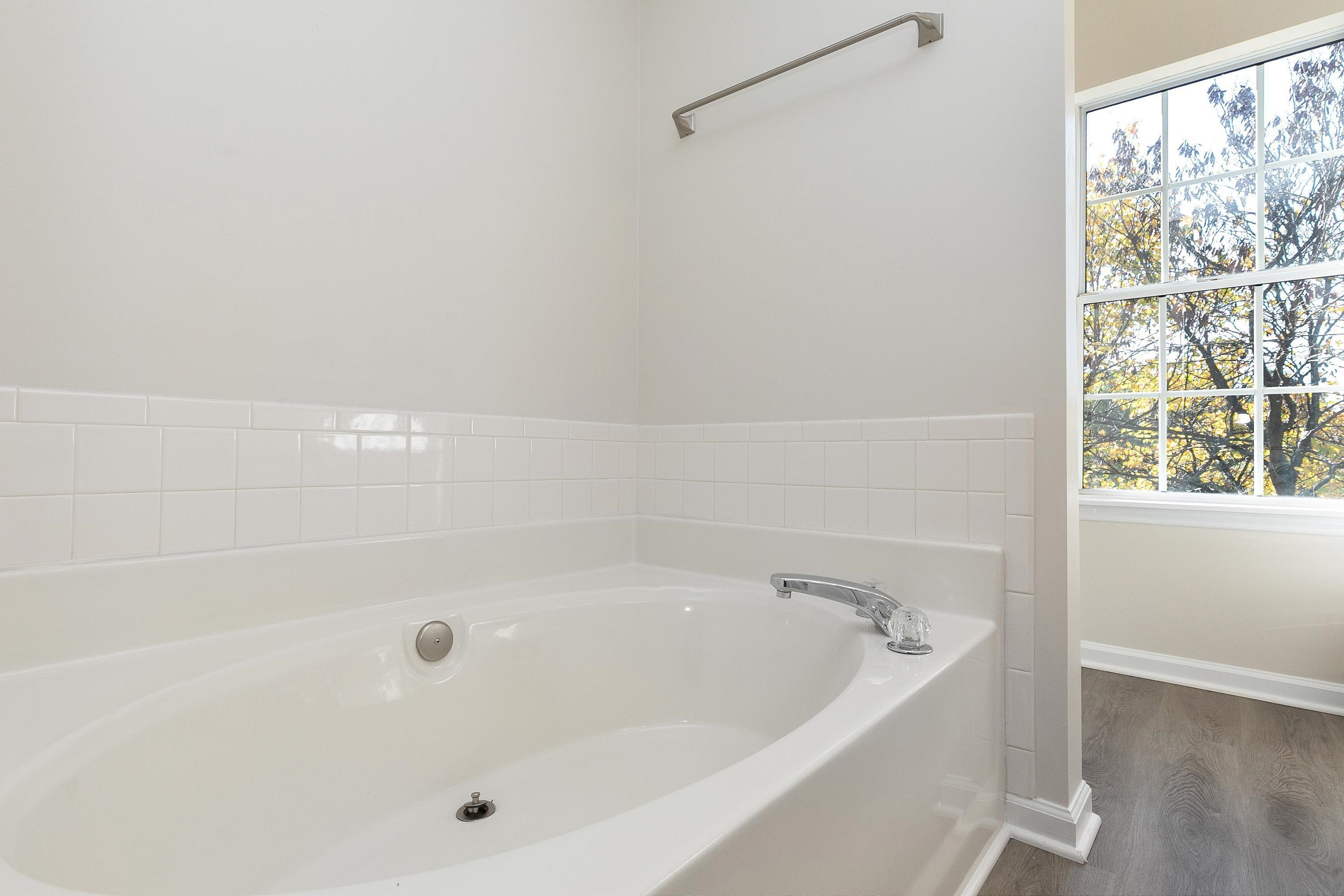 4424 Still Pines Drive Raleigh, NC 27613 - Photo 21 of 34 a white bath tub sitting next to a window