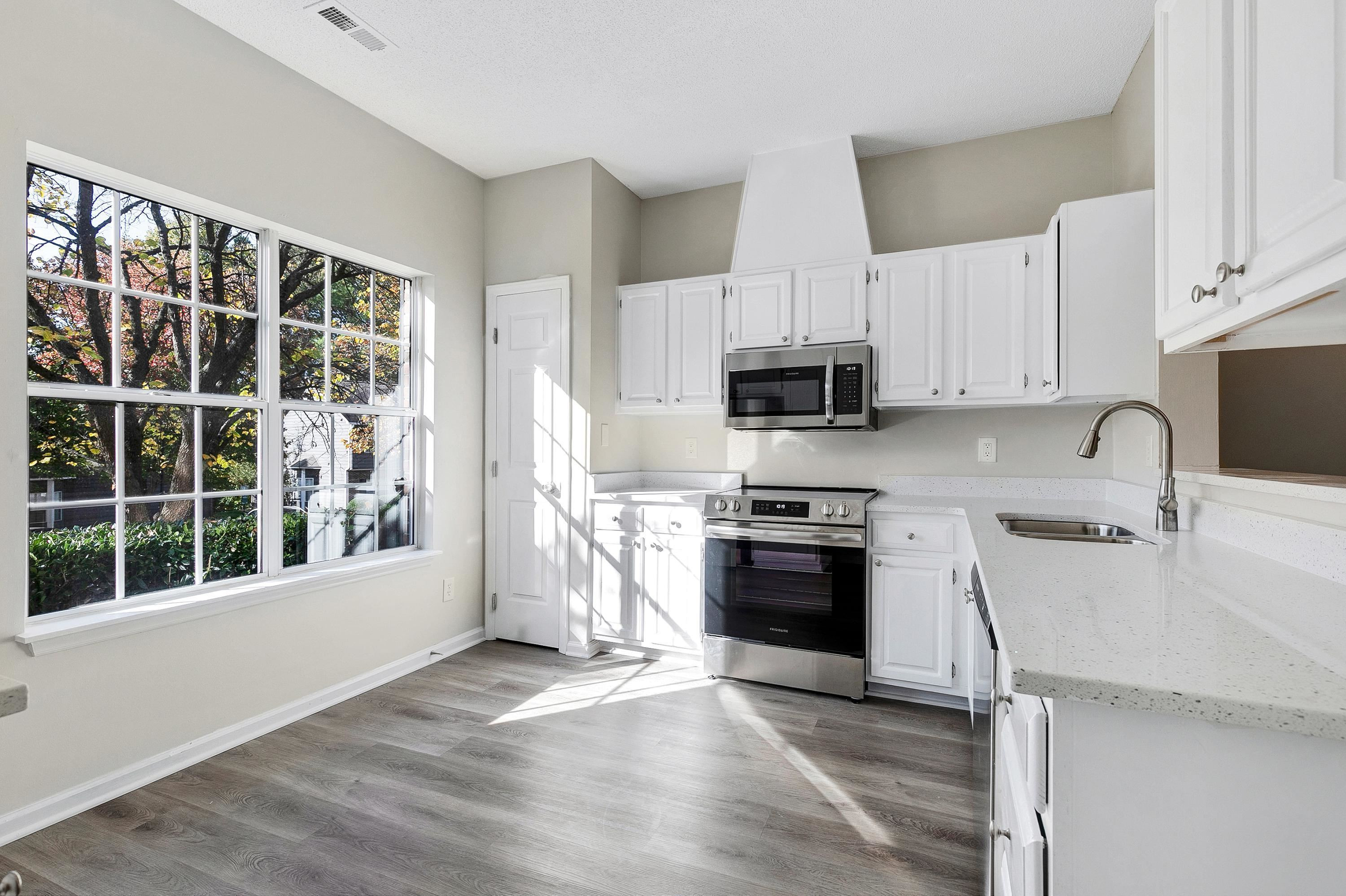 4424 Still Pines Drive Raleigh, NC 27613 - Photo 5 of 34 a kitchen with granite countertop a stove a sink and a microwave