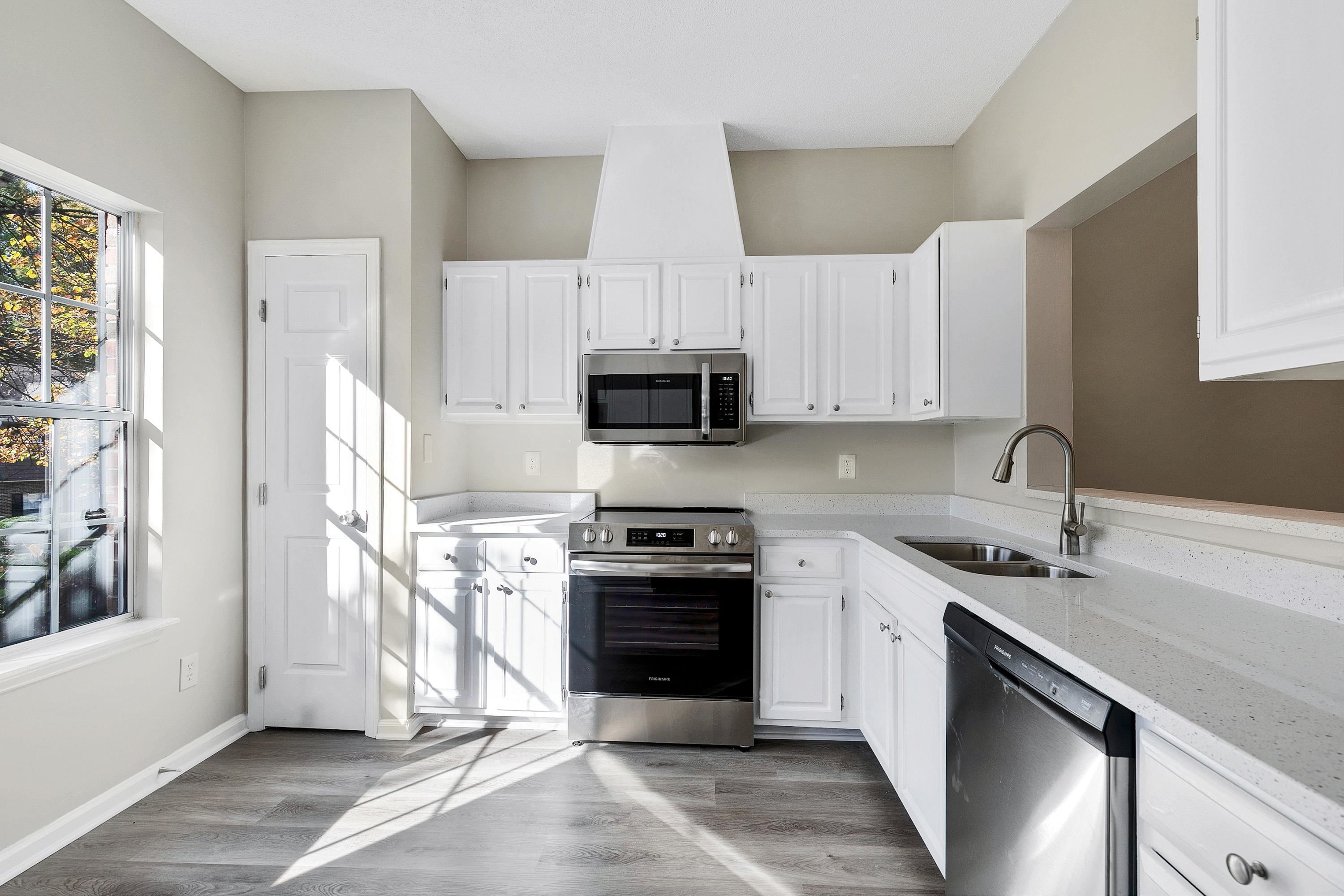 4424 Still Pines Drive Raleigh, NC 27613 - Photo 6 of 34 a kitchen with stainless steel appliances granite countertop a stove a sink and a microwave