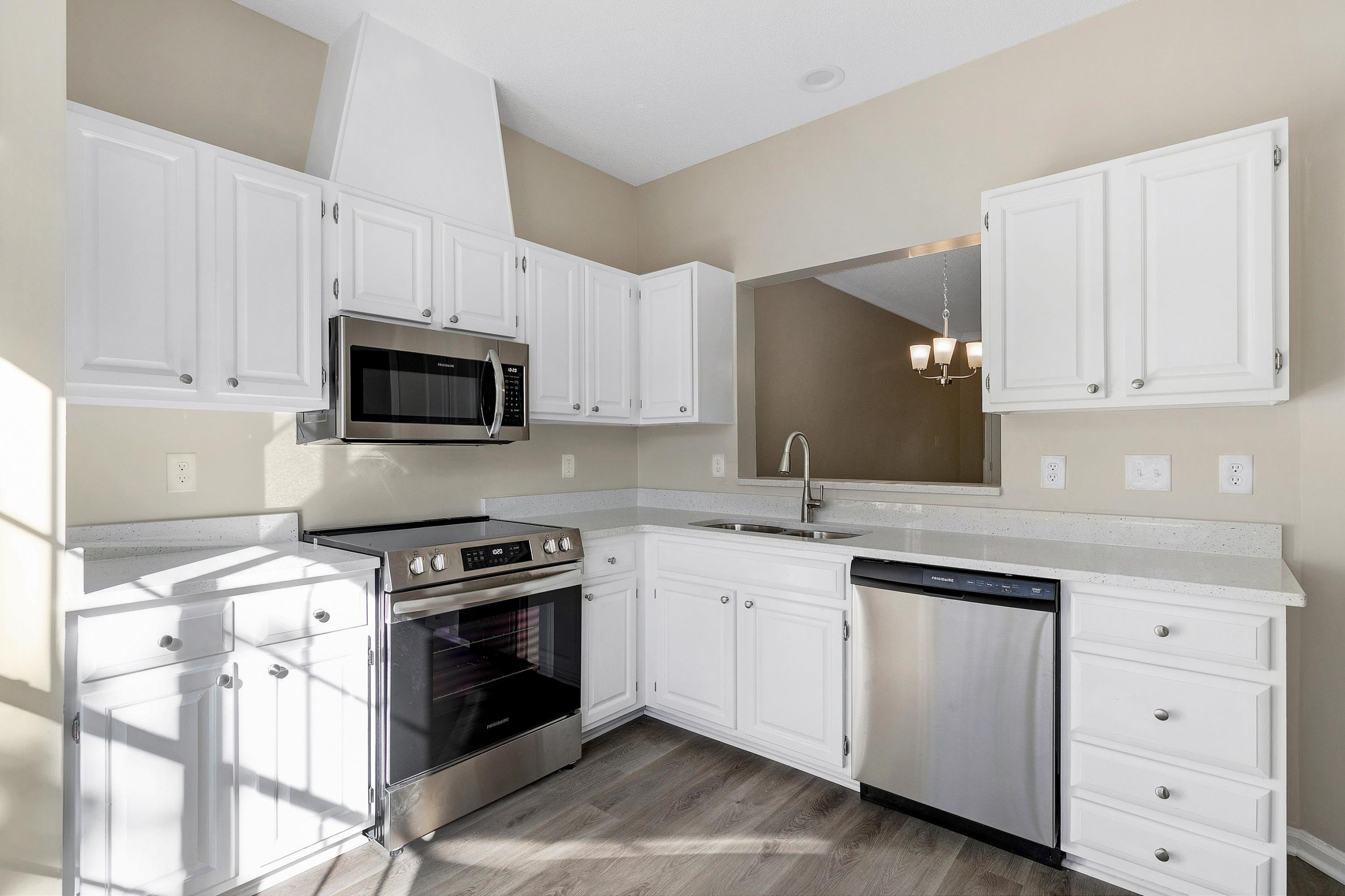 4424 Still Pines Drive Raleigh, NC 27613 - Photo 7 of 34 a kitchen with white cabinets and appliances
