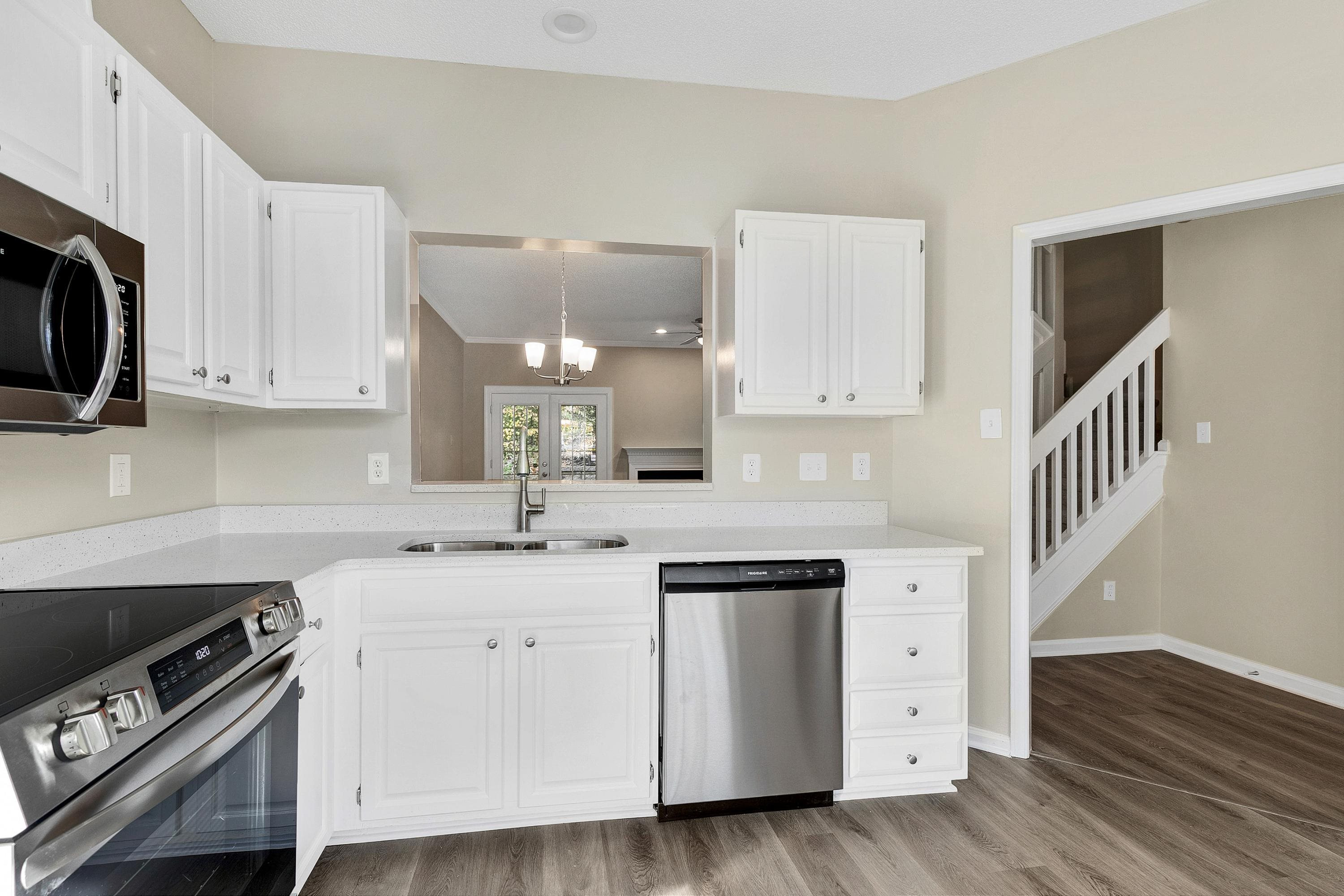 4424 Still Pines Drive Raleigh, NC 27613 - Photo 8 of 34 a kitchen with stainless steel appliances granite countertop a sink and a stove top oven