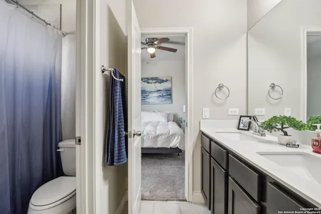 a en suite bathroom with a granite countertop sink and a mirror